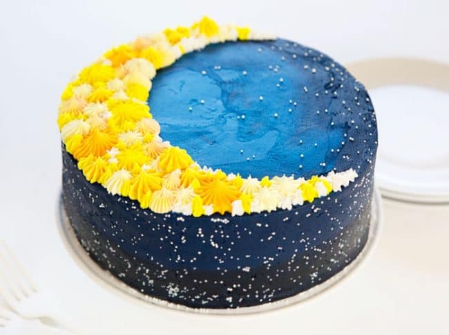 一个深蓝色的星系蛋糕的侧面，上面有一个月亮!
