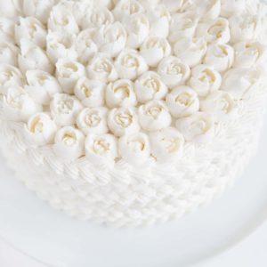 蛋糕上覆盖着白色的奶油，上面还有俄罗斯玫瑰!