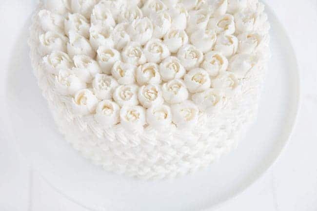 蛋糕上覆盖着白色的奶油，上面还有俄罗斯玫瑰!