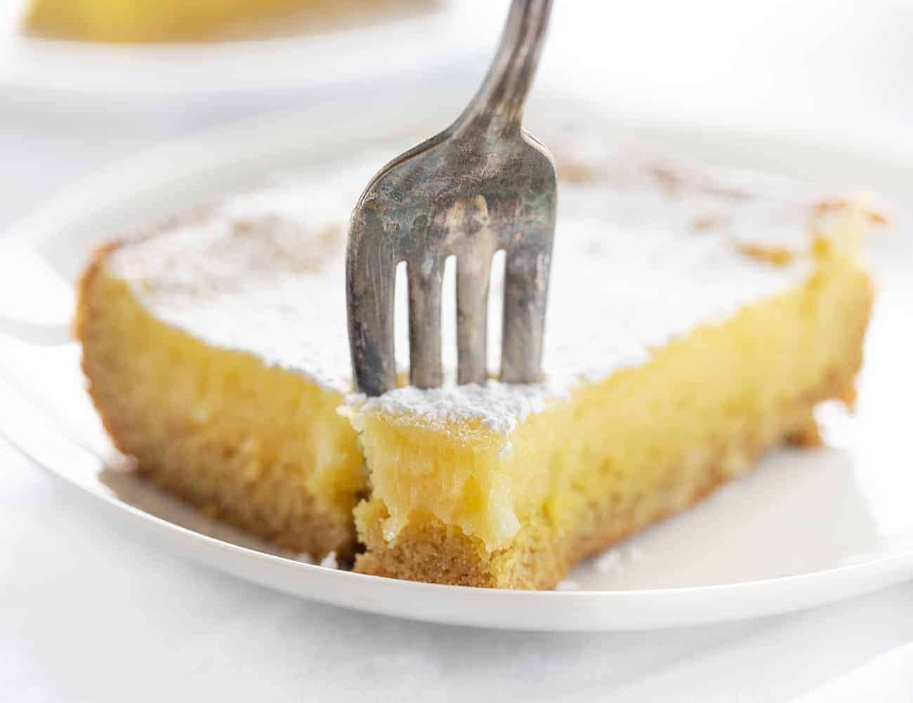叉子采取柠檬ooey粘糊糊的蛋糕