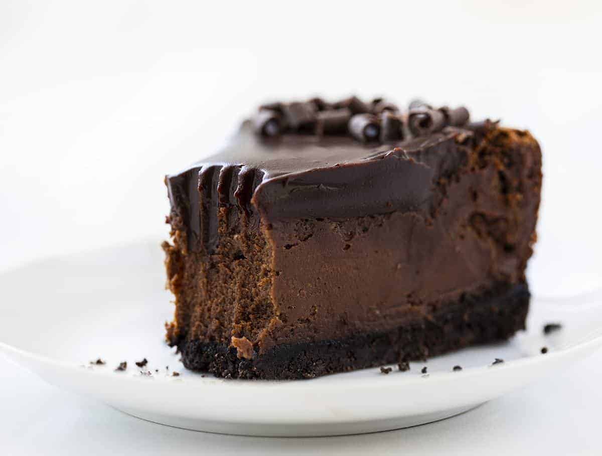 一块巧克力乳酪蛋糕，咬住从尖端取出一块白色板材