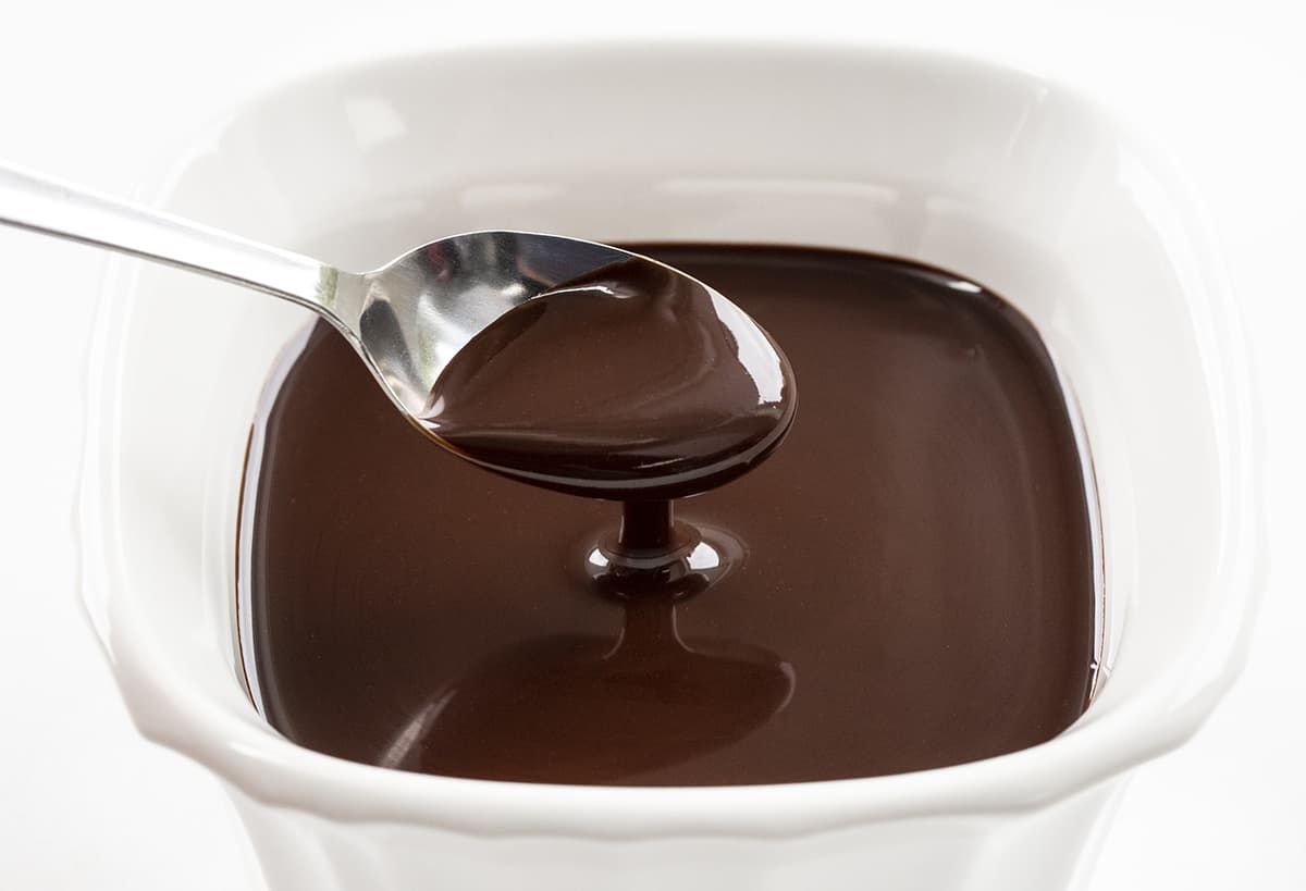 一汤匙自制巧克力软糖酱，装在白色方形容器中