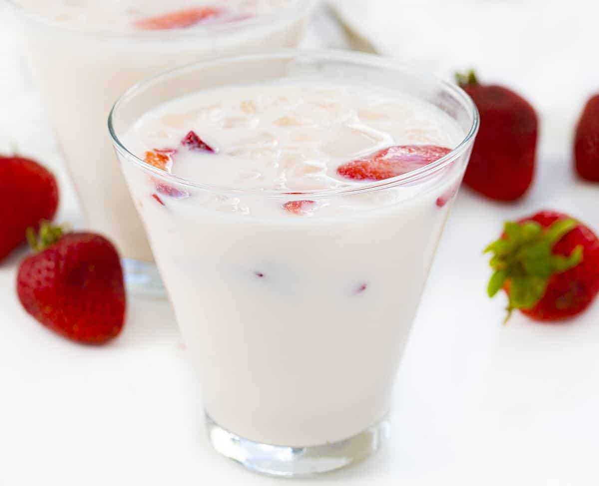 杯草莓和奶油牛奶用草莓在背景中