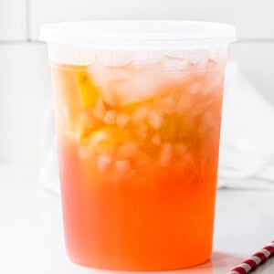 在白色柜台上的容器中，州立式草莓柠檬水。