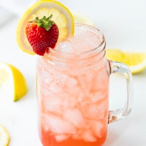玻璃杯配威士忌草莓柠檬水，草莓和柠檬装饰。